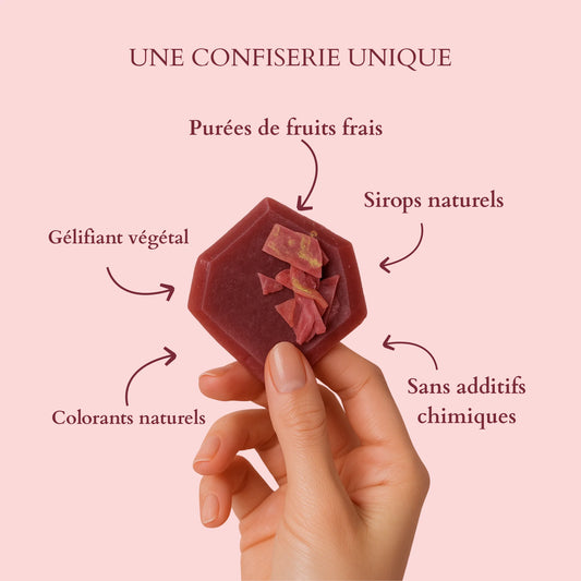 Main tenant un cristal comestible rouge avec le texte “Une confiserie unique – Parfum de fruits frais, Gélifiée végétale, Sirop aromatisé, Fabrication artisanale, Création originale.”